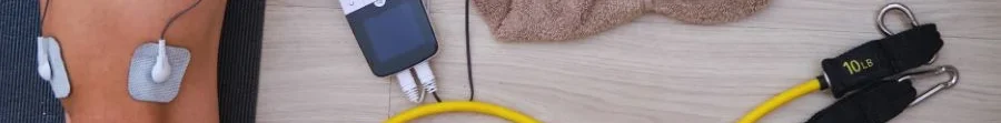 Elettrodi posizionati sul quadricipite per elettrostimolazione muscolare post-infortunio con dispositivo professionale a terra.
